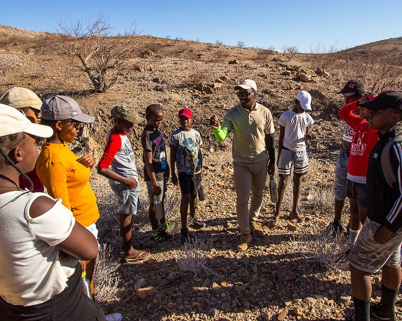 The children gather round to listen to their guide.