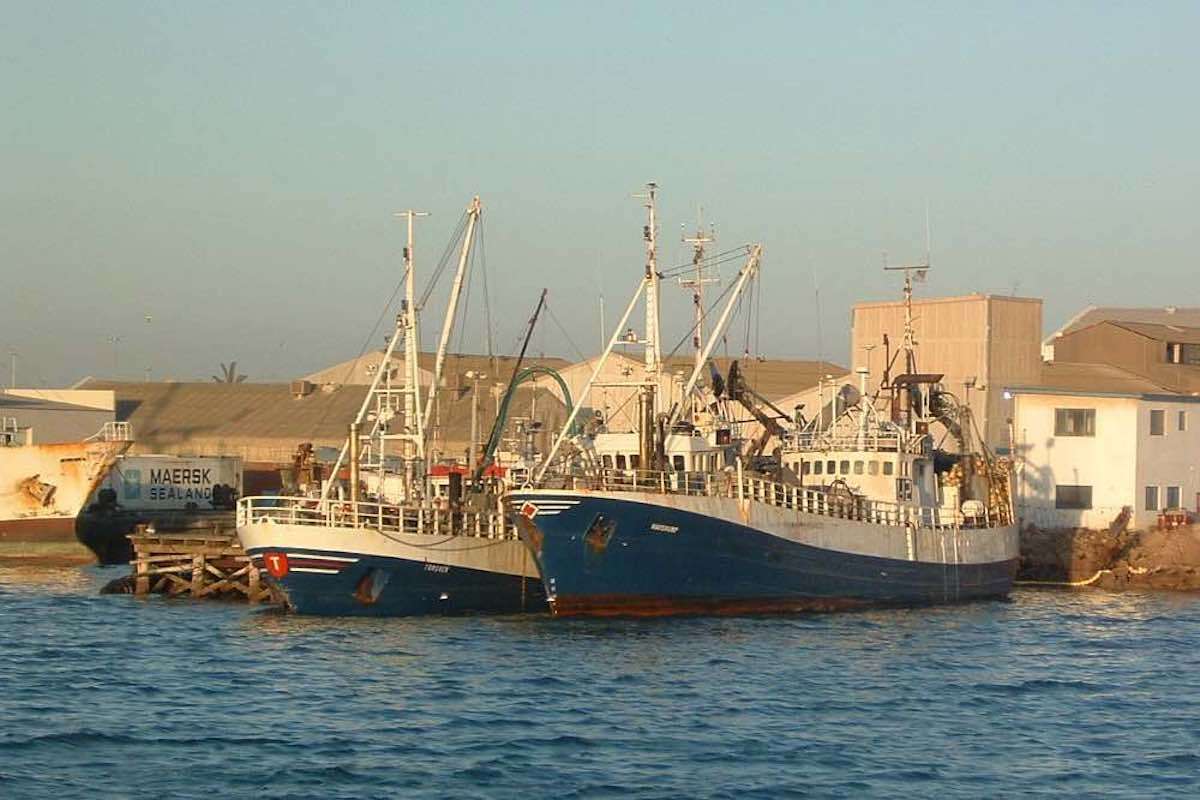 Two fishng vessels moored at a quay.