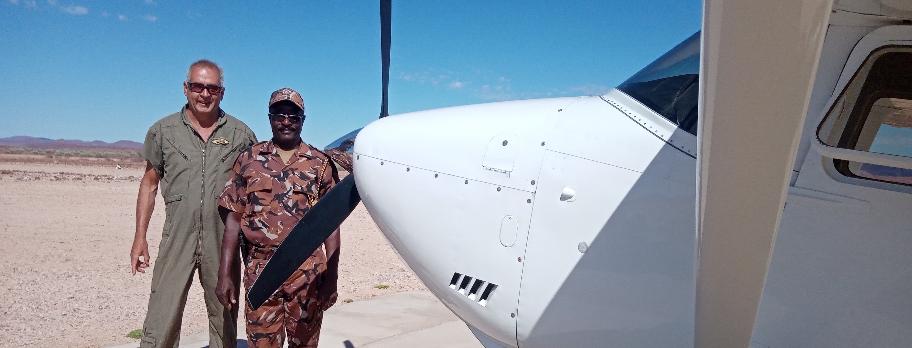 Two men, including the author stand next to the plane.
