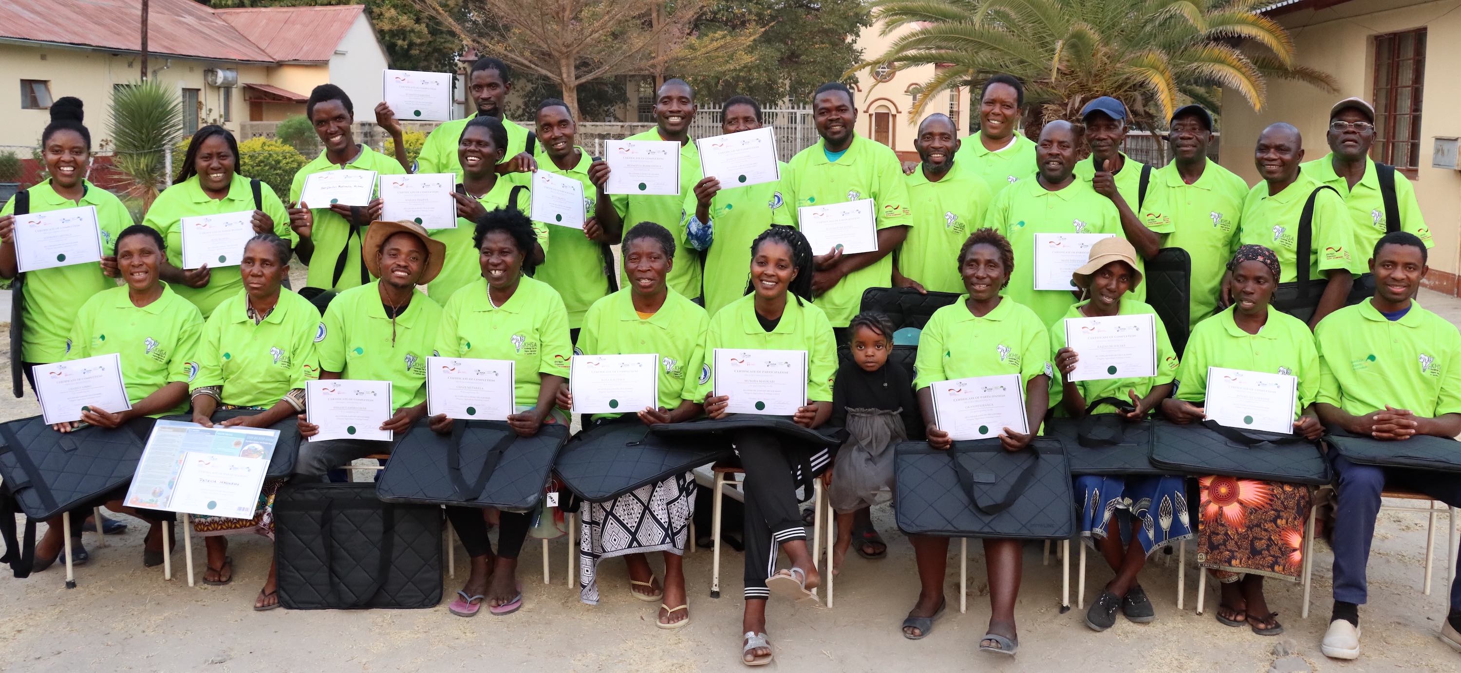 Three people examining a white cylinder.