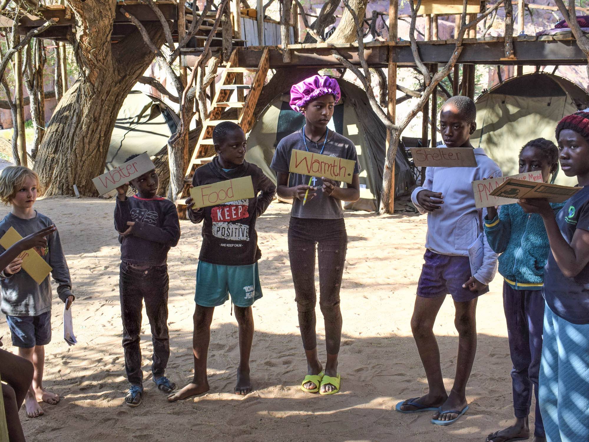 Children holding signs indicating important needs.