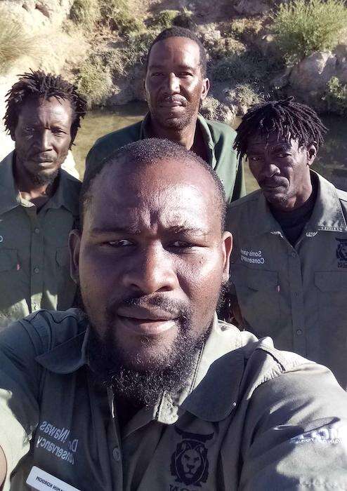 Four uniformed lion rangers.