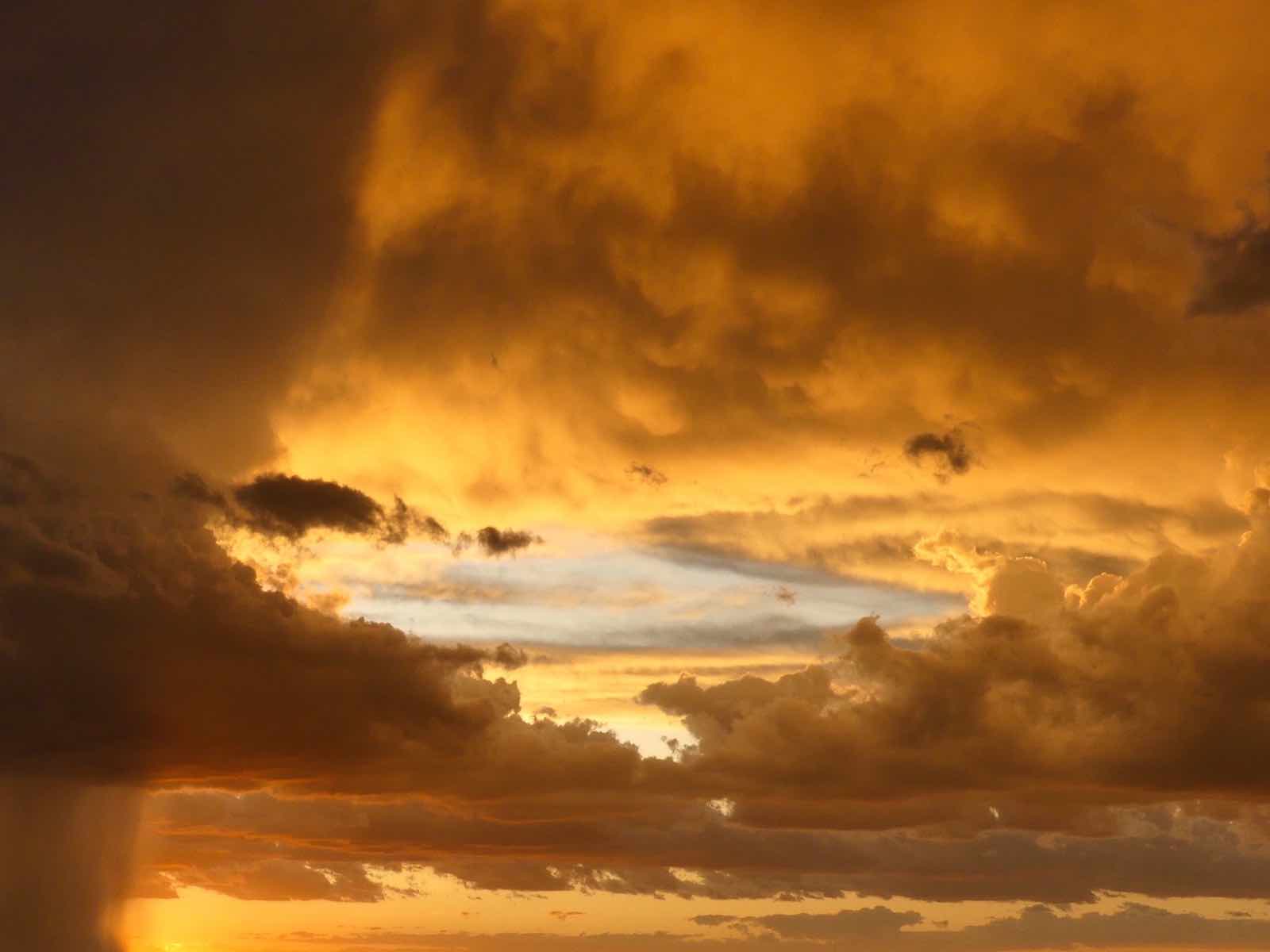 Stunning orange-lit clouds and a rain storm.