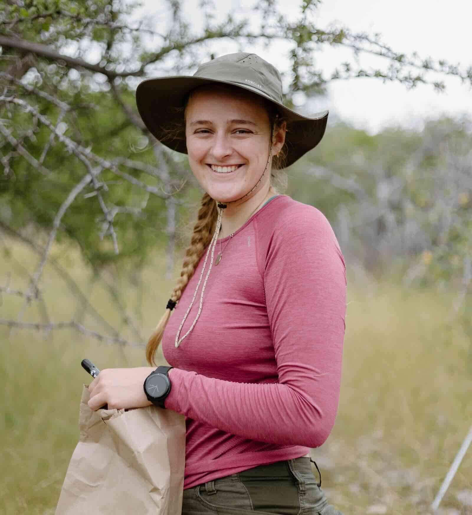 Alice Jones holds a brown paper bag and smiles for the camera.