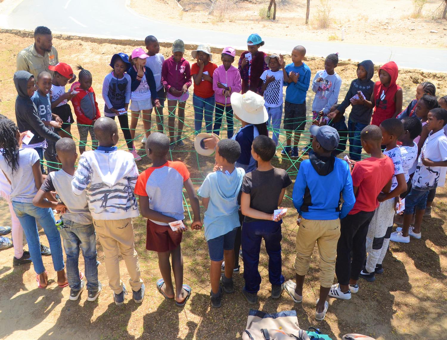 A group of KEEP students enact the web of life, demonstrating how all life is interconnected.
