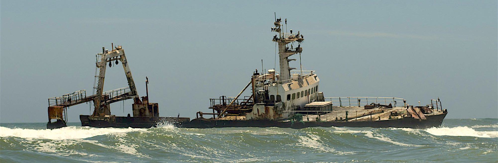 A derelict ship drifts in high seas.
